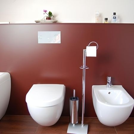 Badezimmer mit Toilette an einer roten Wand